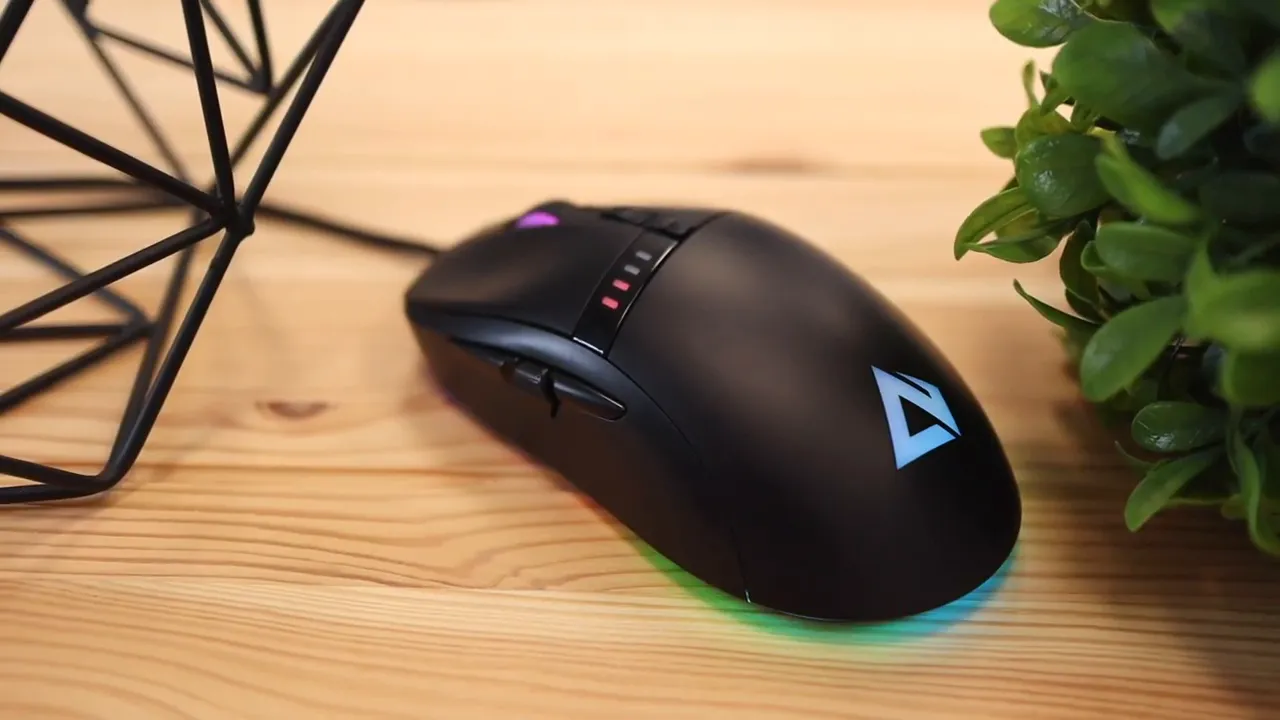 Black AUKEY gaming mouse with illuminated logo and RGB light strip on a wooden desk