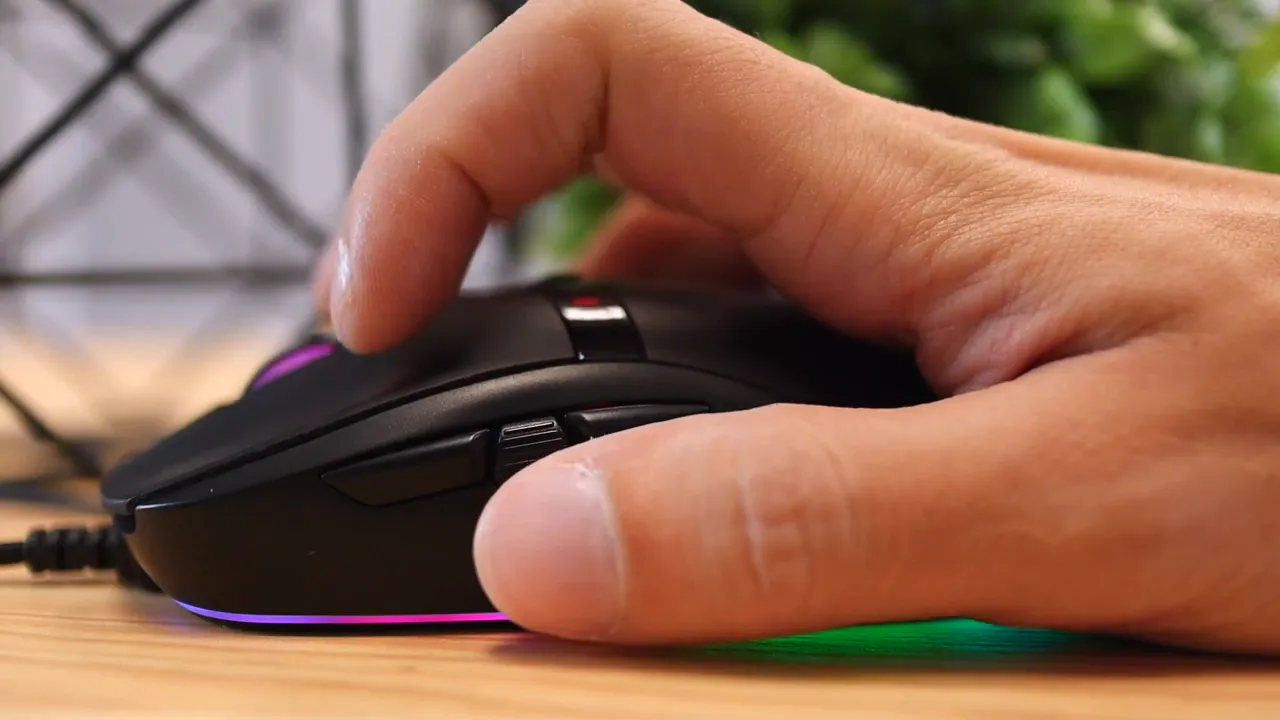 Hand pressing the main buttons and side area of the mouse in a close side view