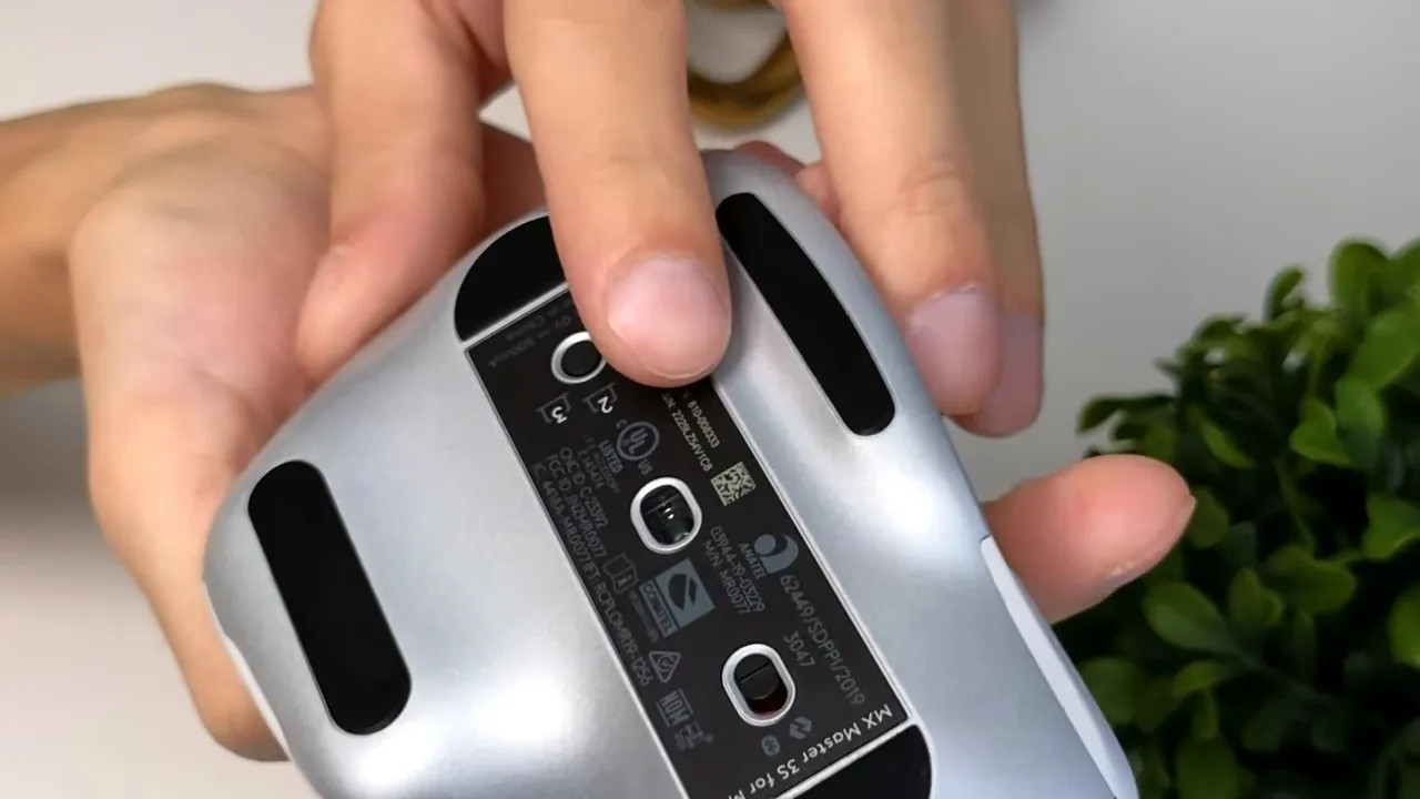 Clear close-up of MX Master 3s underside showing optical sensor, glide pads and pairing buttons