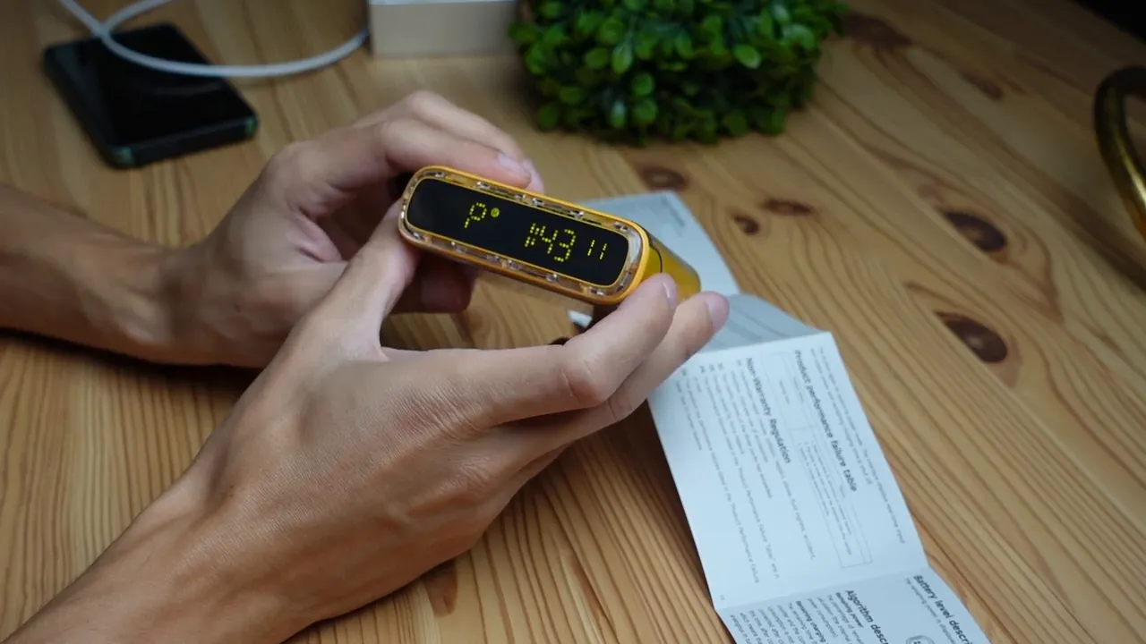 Clear close-up of the Starship Seer front LED display showing the time while hands hold the device, illustrating the clock-setting process.