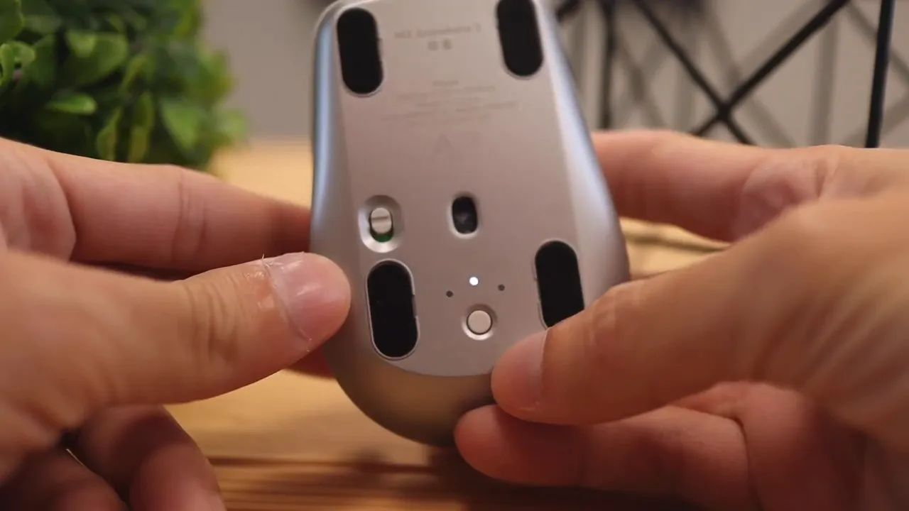 Bottom of mouse with device switch button and indicator lights visible