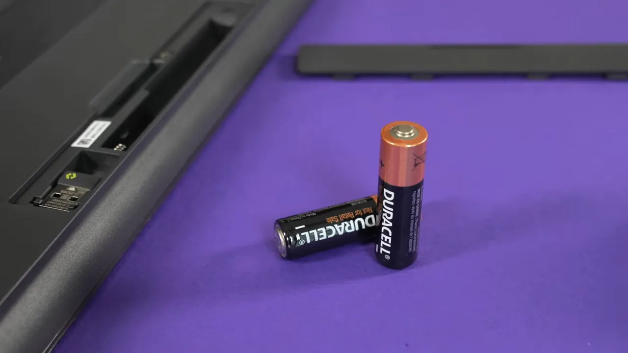 Open battery compartment of the Logitech K650 with Bolt USB receiver visible and two AA batteries in the foreground