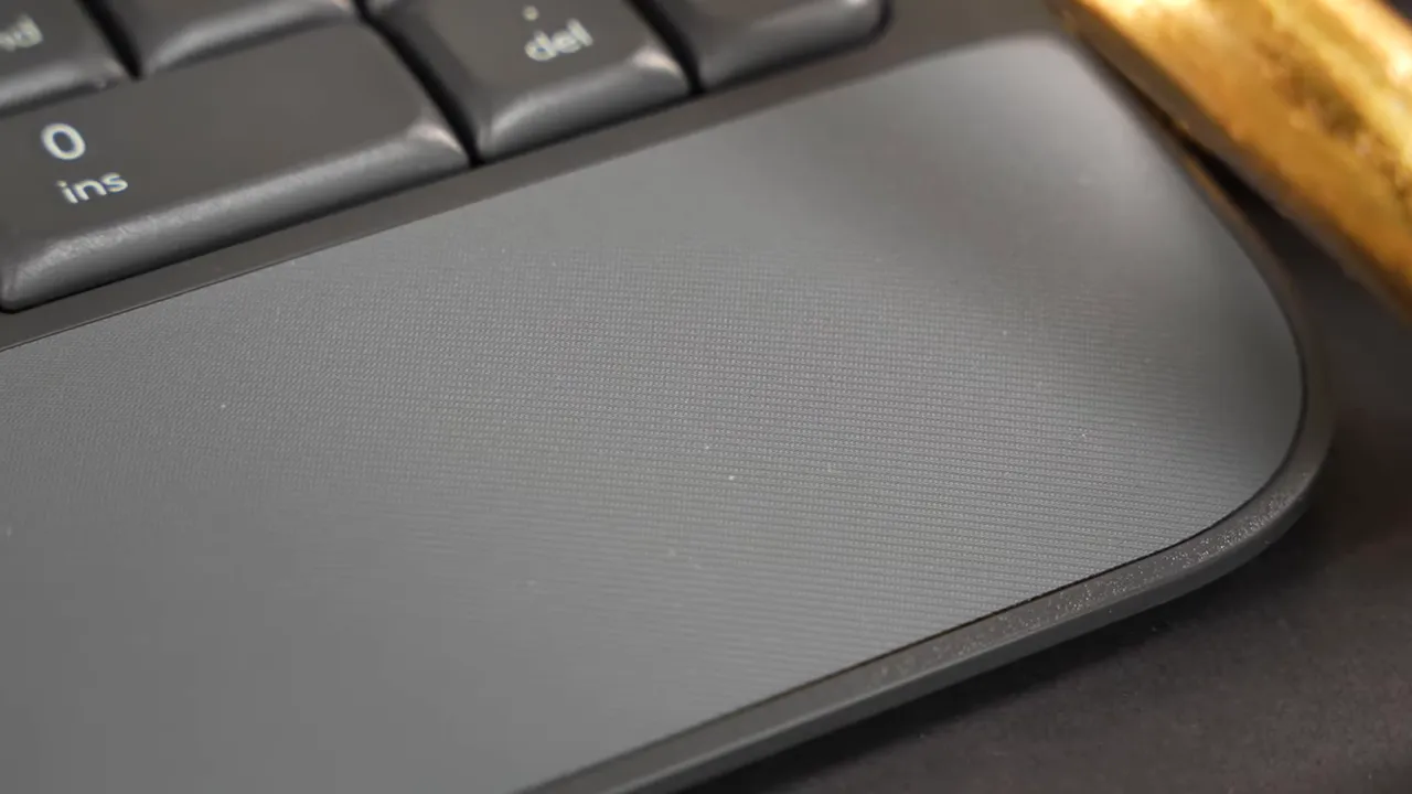 Logitech K650 wrist rest showing textured rubber surface, rounded edge and nearby keys to illustrate short length