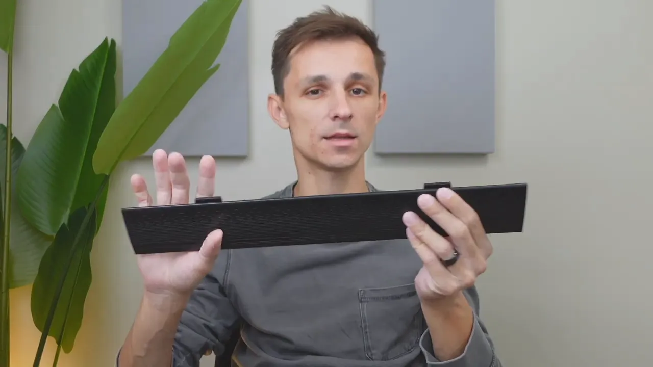 Risophy keyboard magnetic wrist rest held detached, clearly showing the textured surface and attachment clips.