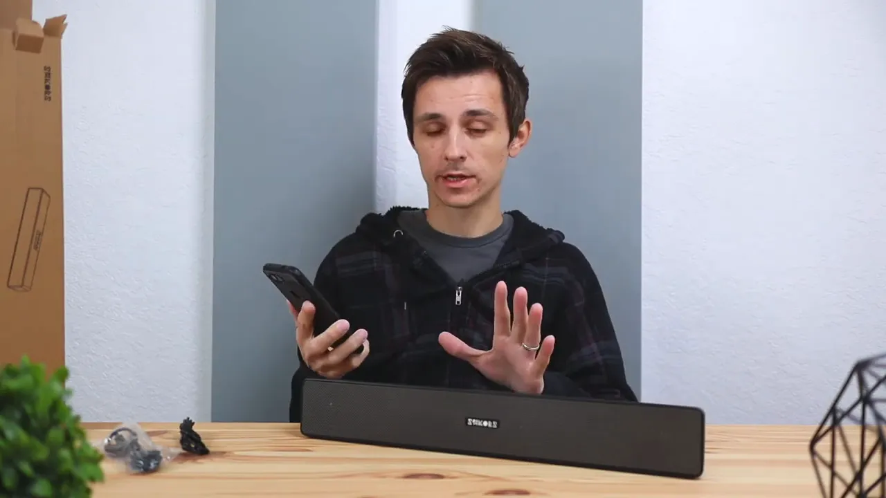 Reviewer using a phone with the Sakobs DS5103 speaker for Bluetooth pairing