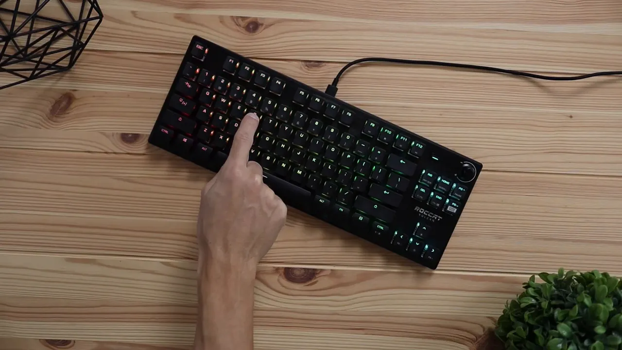 Top down view of keyboard while a finger points to function row and lighting controls
