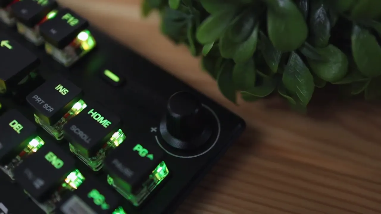 Close up of volume knob and nearby media keys lit in green