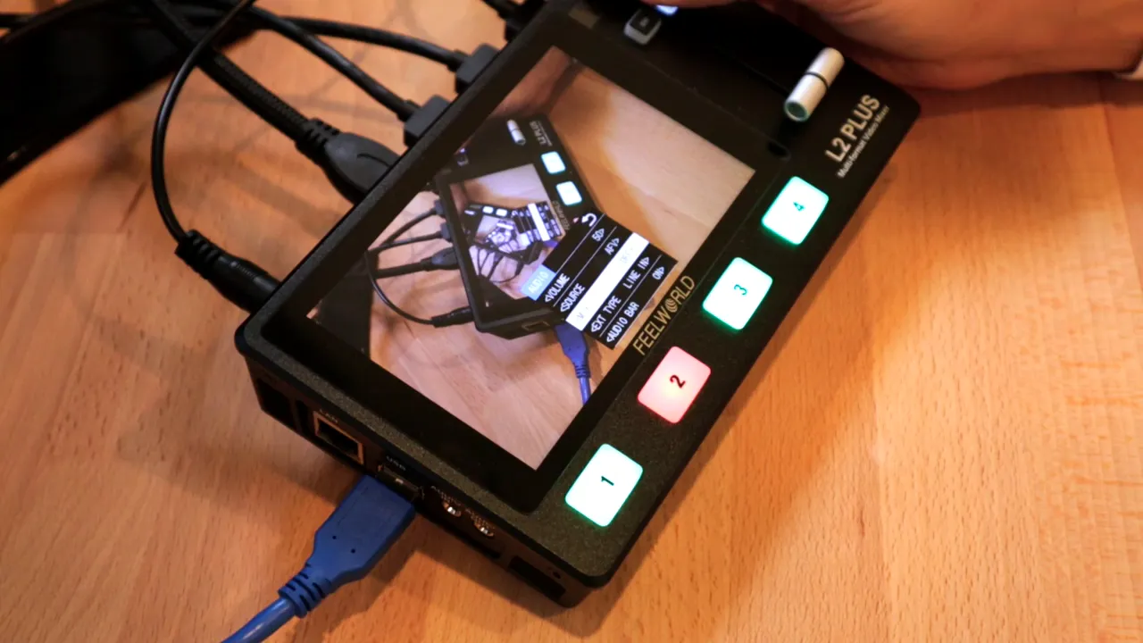 Feelworld L2 Plus top view showing a blue USB cable and a 3.5mm audio jack plugged in