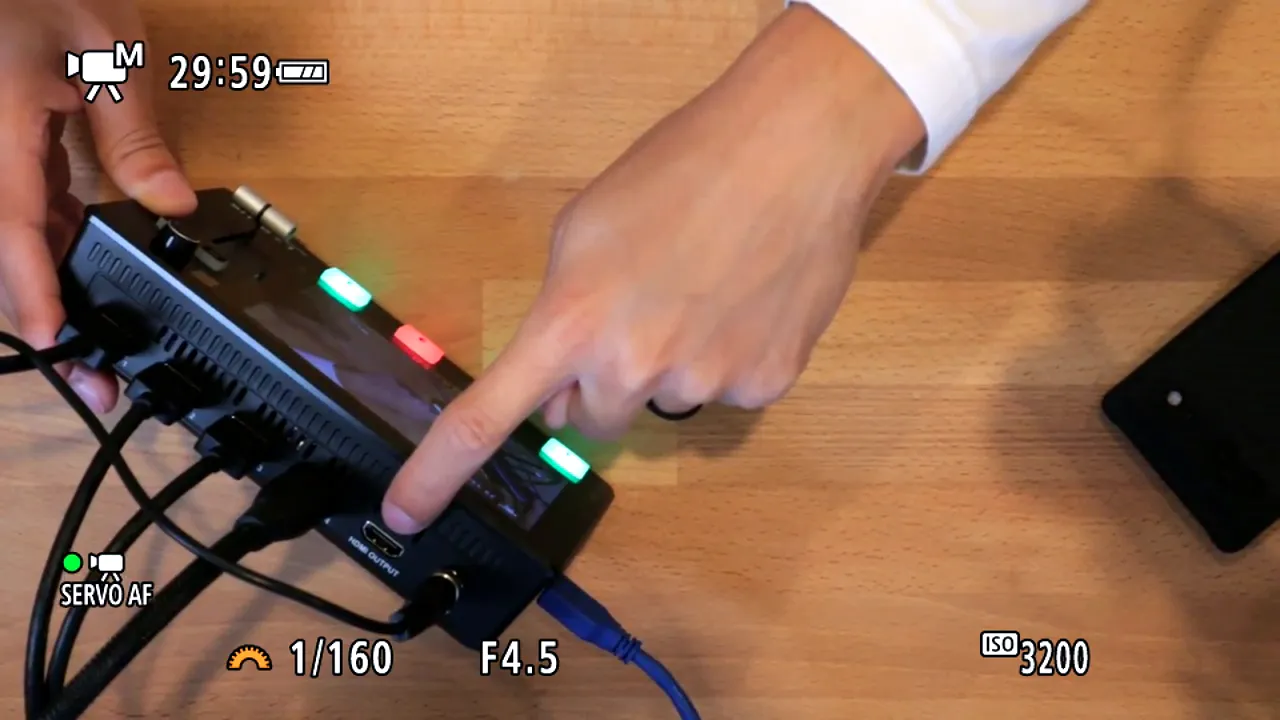 Close-up of the Feelworld L2 Plus rear showing multiple HDMI inputs and the clearly labeled HDMI OUTPUT port with cables connected.