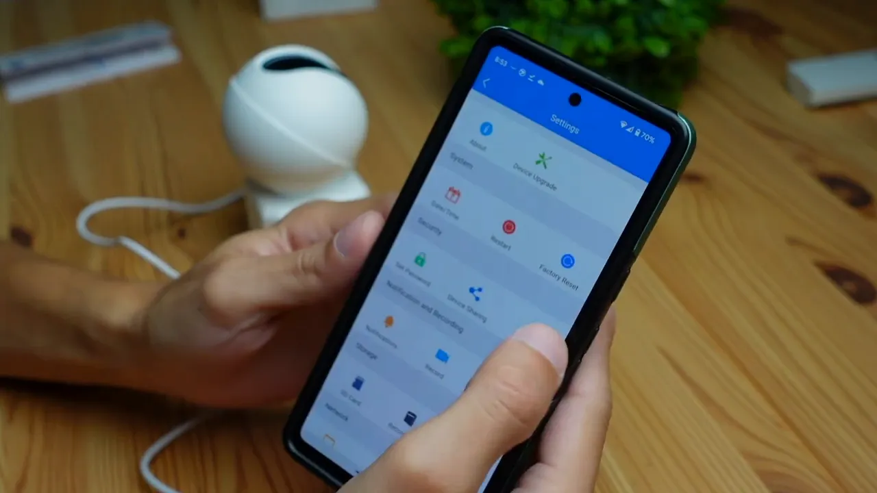 Phone displaying the Annke app Settings screen (storage, detection, factory reset options) with the Annke Creator Pro camera visible in the background