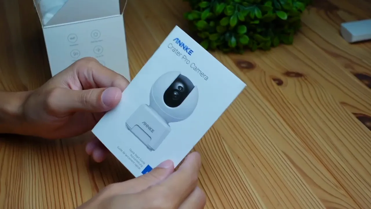 Annke Creator Pro camera retail box held over a wooden table