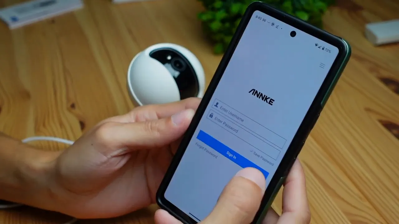Phone showing Annke app sign-in screen with Creator Pro camera in the background