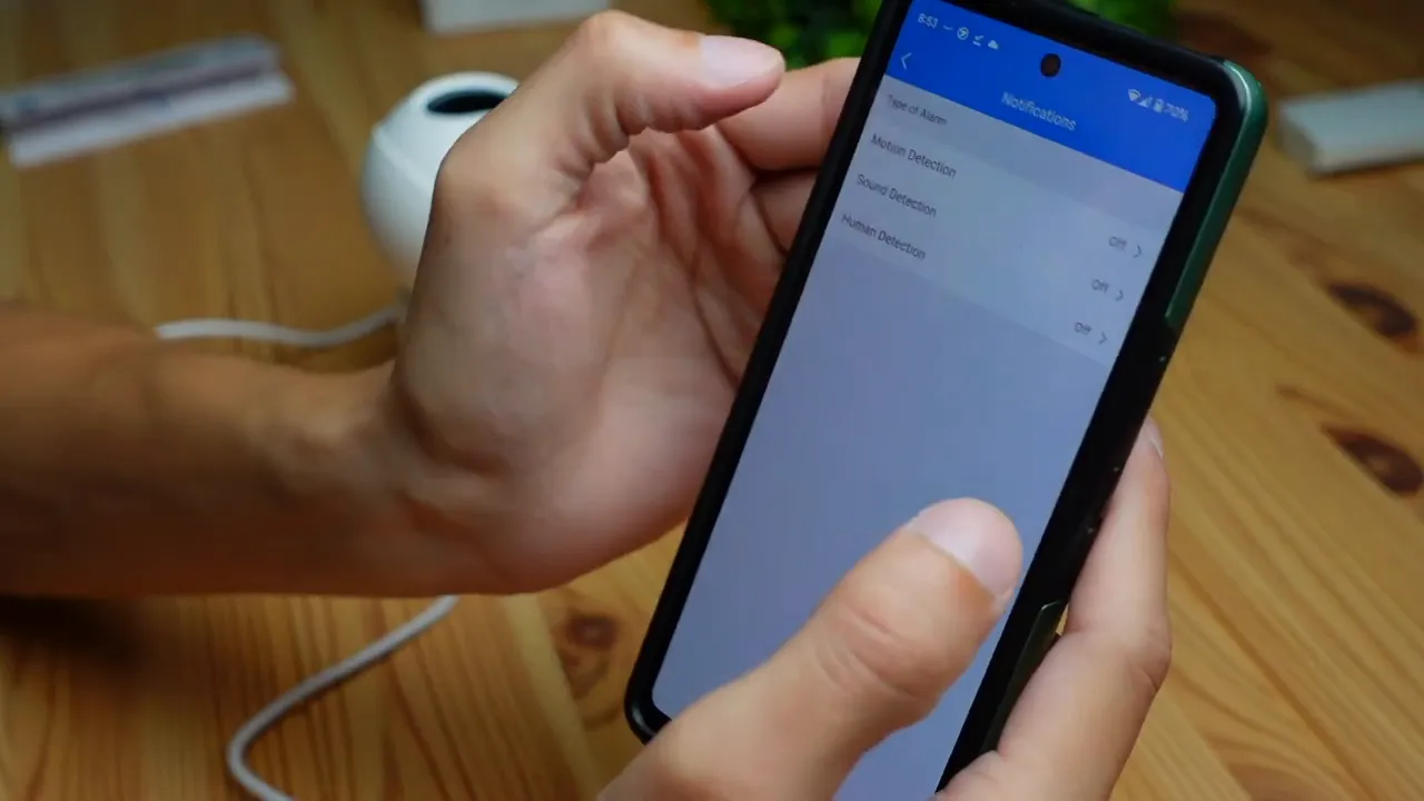 Smartphone showing the Annke app Notifications screen listing Motion Detection, Sound Detection and Human Detection with the Annke Creator Pro camera visible in the background
