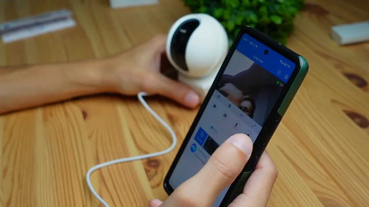 Phone displaying Annke live video and control buttons with the Creator Pro camera and power cable visible on a wooden table