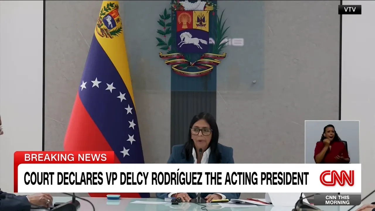Delcy Rodríguez speaking at a press conference with the Venezuelan flag and national coat of arms visible behind her, shown beneath a breaking-news banner.