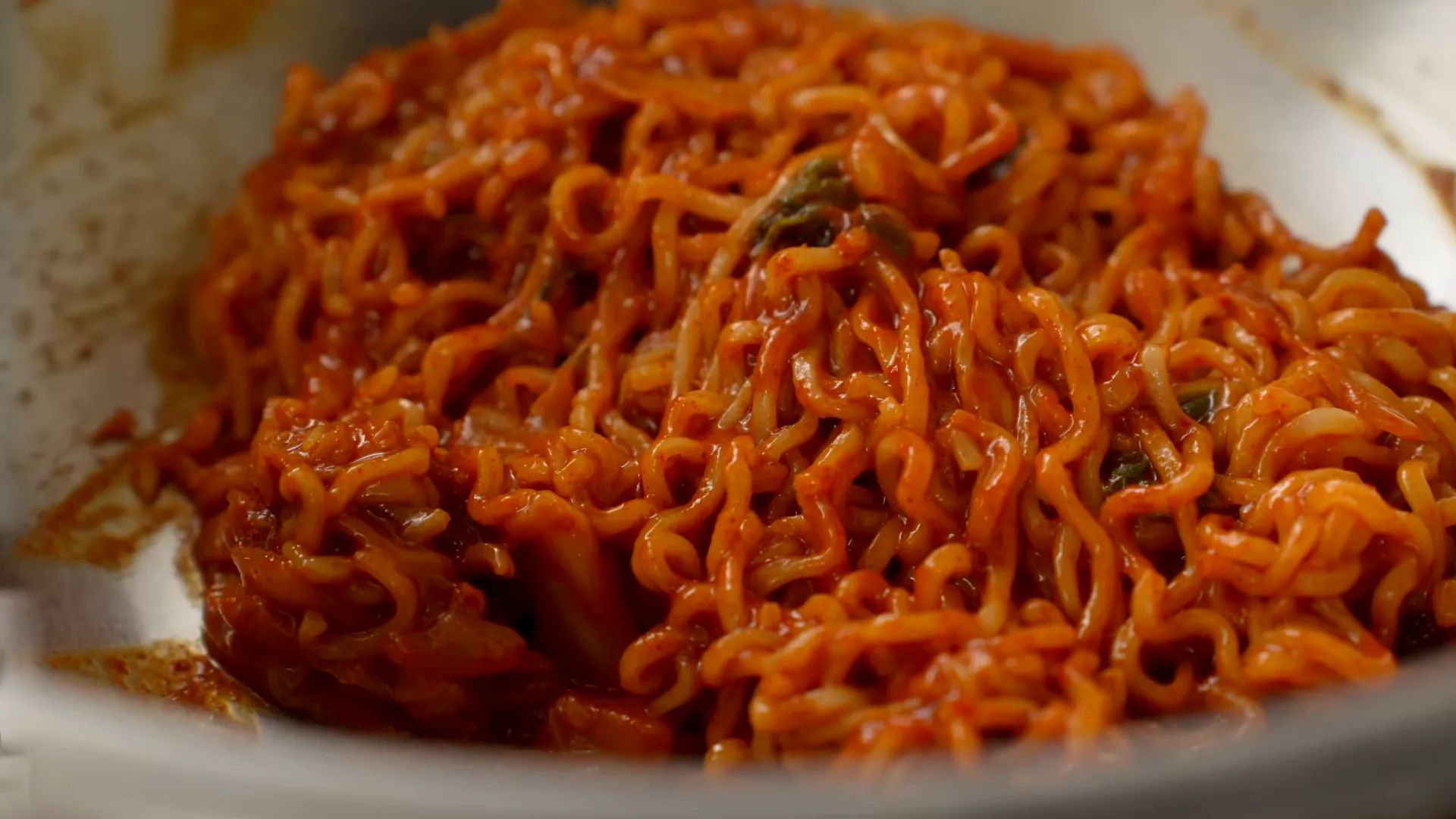 Mixing chilled ramen with gochujang-kimchi sauce for bibim guksu