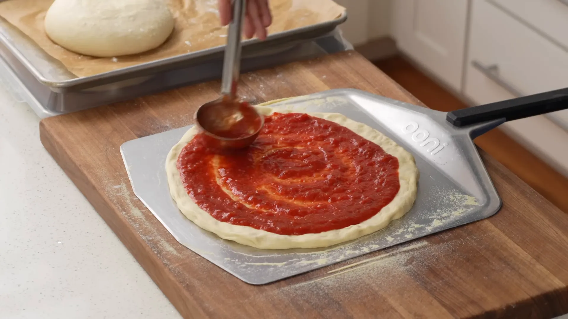 Assembled large pizza on peel, ready to launch into oven