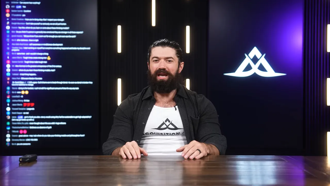 Centered presenter speaking to camera with live chat panel to the left and illuminated brand logo on the right