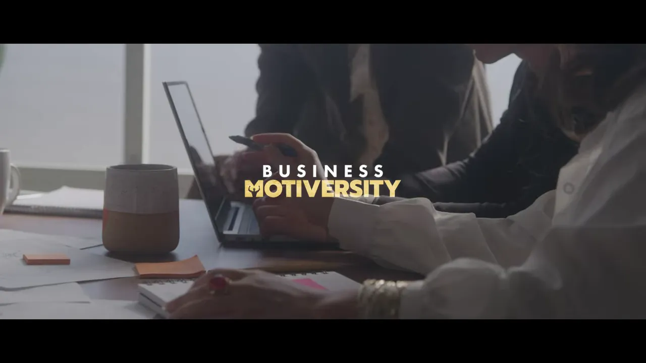 Hands-on team planning over a laptop, notebook and sticky notes with 'Business Motiversity' logo overlay