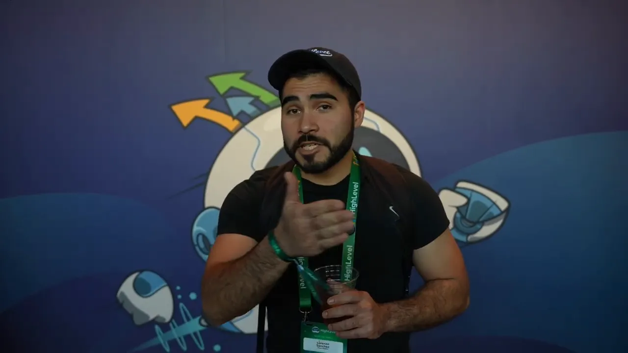 event speaker reaching forward with an inviting hand gesture in front of a blue illustrated backdrop