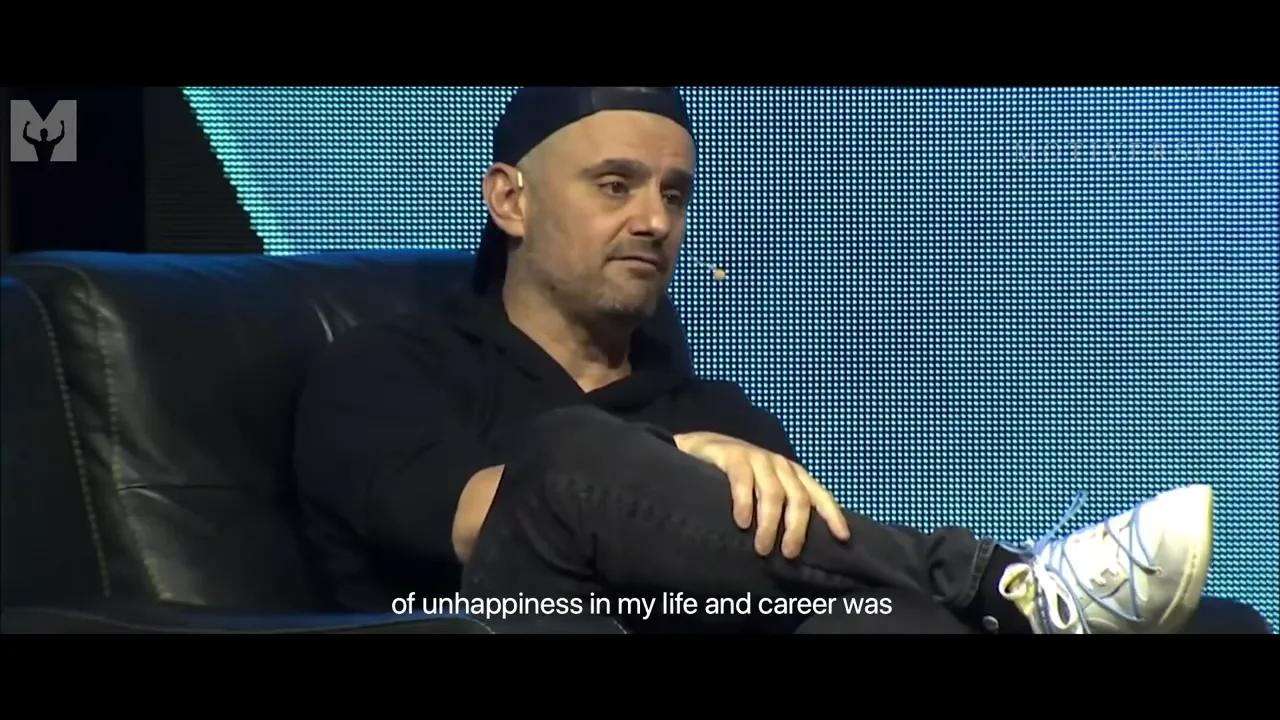 motivational speaker sitting thoughtfully on stage with LED-panel background