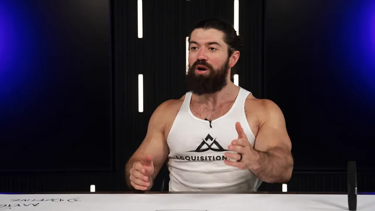 Presenter explaining with open-hand gesture toward the viewer, dark studio background with vertical lights and whiteboard surface