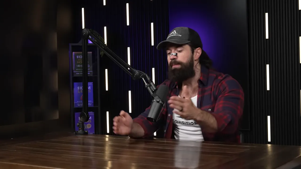 Wide shot of podcast host leaning forward and gesturing while speaking into a microphone in a dark studio