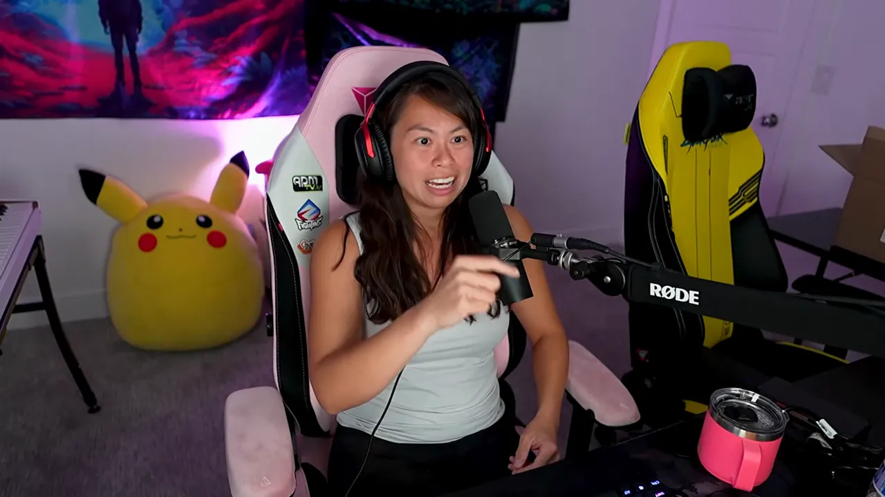 Streamer at desk pointing and speaking into a Rode microphone, demonstrating a workflow