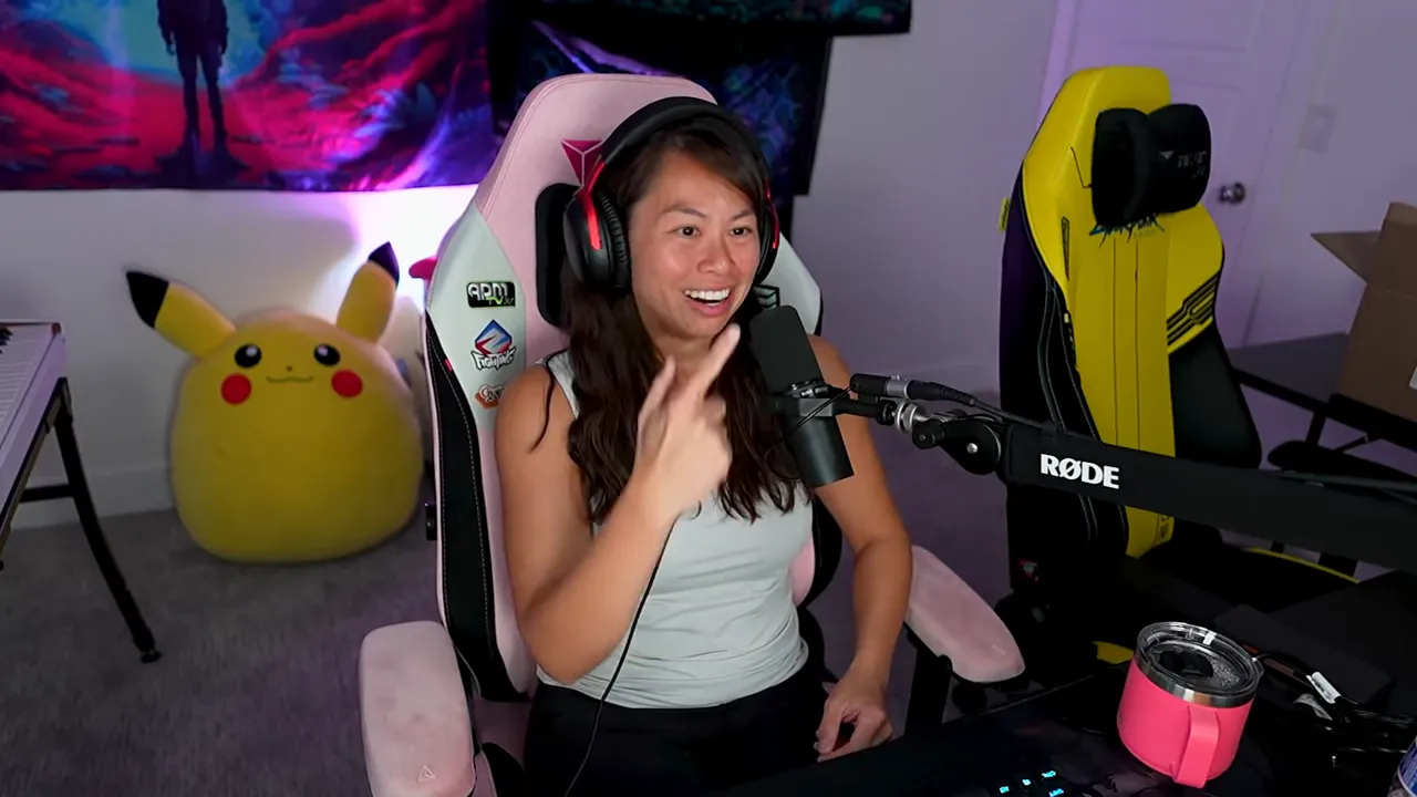 Creator smiling and gesturing enthusiastically while speaking into a studio microphone in a home recording setup.