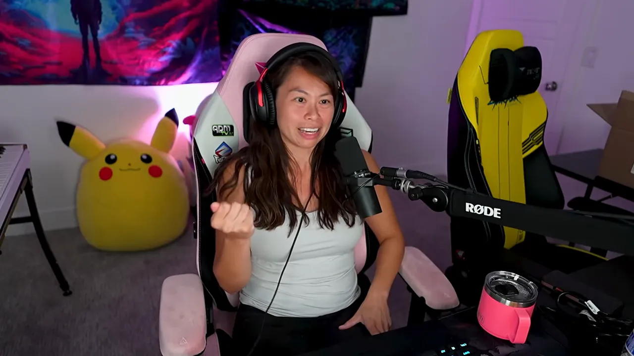 Creator at desk smiling and explaining into a microphone with headset and studio background