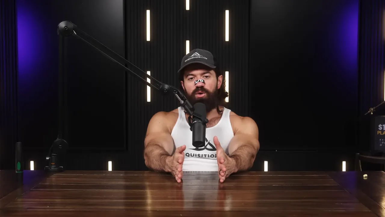 Podcast host with hands framing a space in front of him, speaking into a microphone with studio backlighting