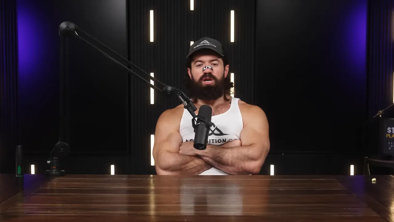 Centered podcast host at a wooden table with arms crossed in front of a boom microphone, dark acoustic panels and purple accent lighting