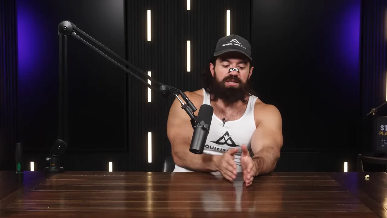 Podcast host at a table using both hands to frame a small space, indicating a single specific offer; boom microphone and dark studio background with vertical lights