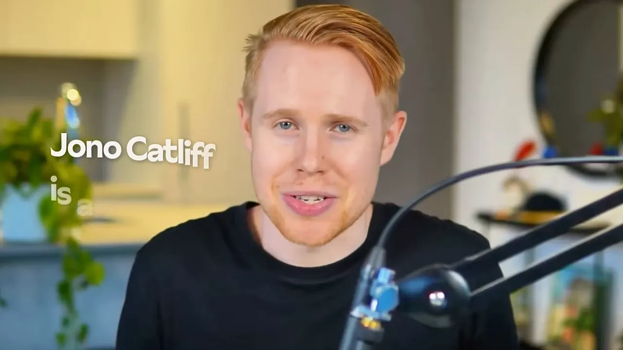 Presenter smiling to camera with microphone and blurred home-office background