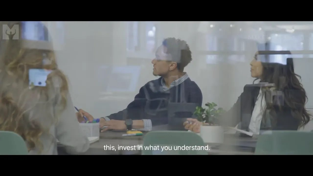 Office meeting through glass with subtitle 'this, invest in what you understand.'