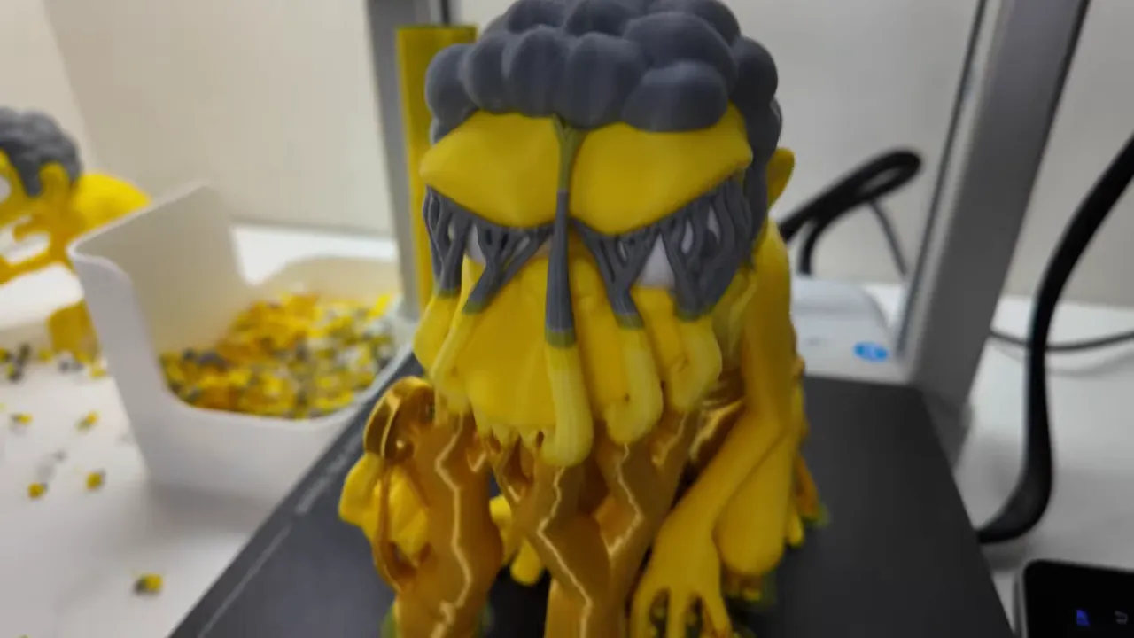 Finished yellow, brown, and grey multicolour character model on the Kobra X build plate