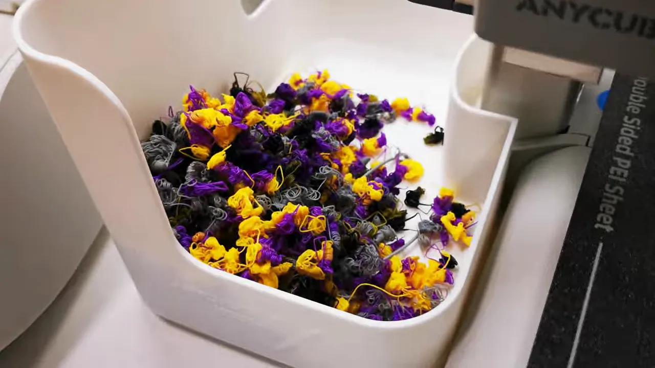 White purge tray filled with purple yellow and grey filament purge waste