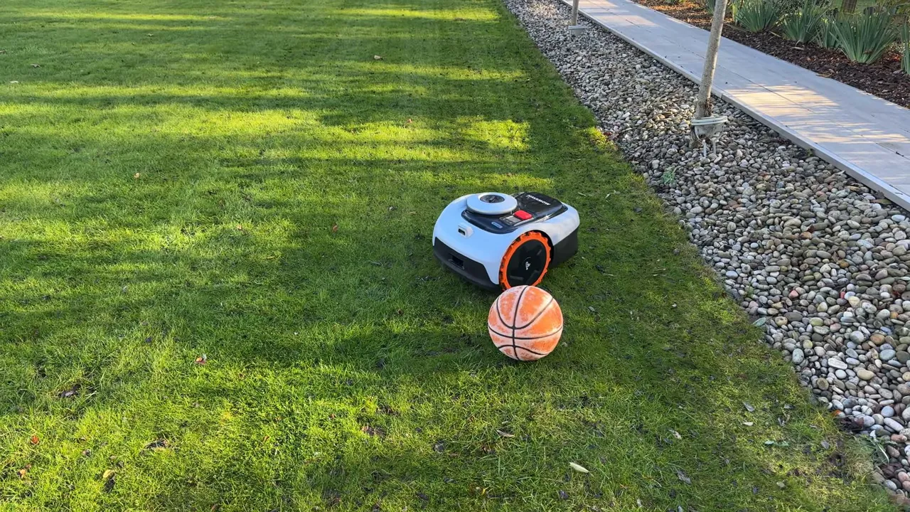 Navimow i105 robotic mower next to a basketball on a lawn showing obstacle avoidance