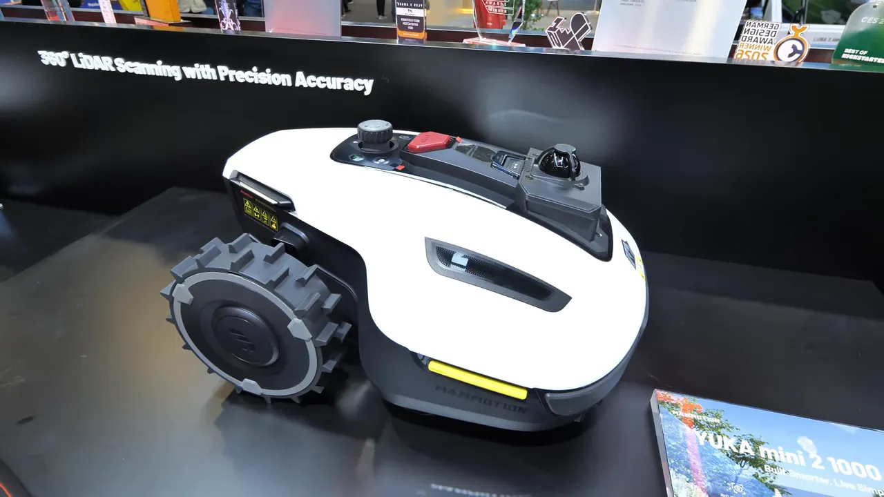Well-lit side view of YUKA Mini 2 robot mower on display showing LiDAR unit, controls and treaded wheel