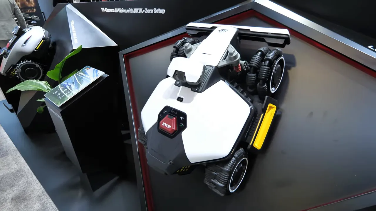 Luba Mini 2 AWD on display showing the STOP button, top sensor housing, omni-wheels and the yellow underbody edge-cutting disc.