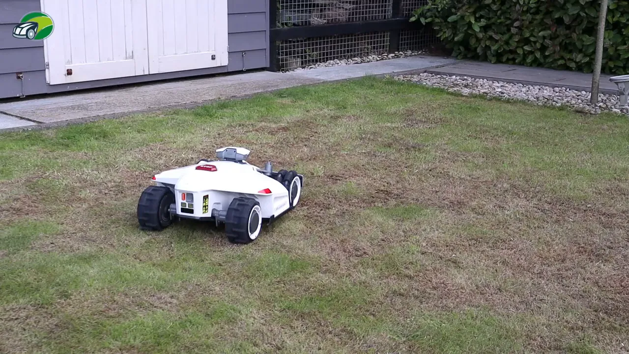 Luba 2 robotic mower mowing a front lawn with patchy grass, visible path and shed in the background