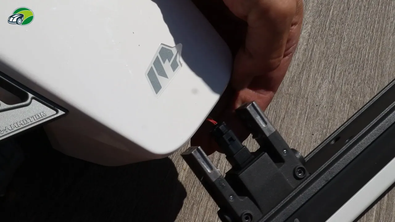 Luba 2 front bumper being aligned to the mower with clip connector visible