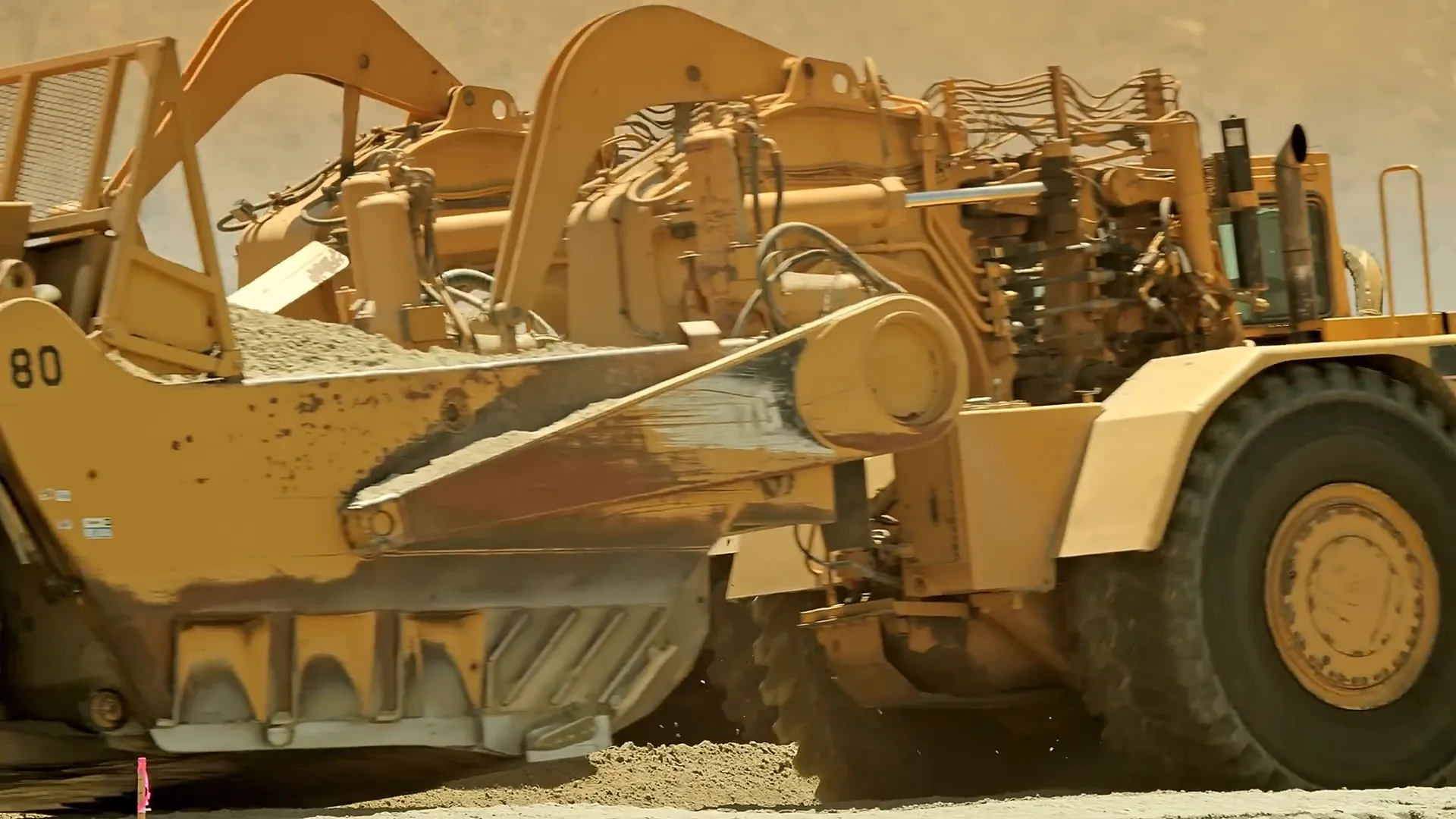 Scraper machine scraping soil into hopper