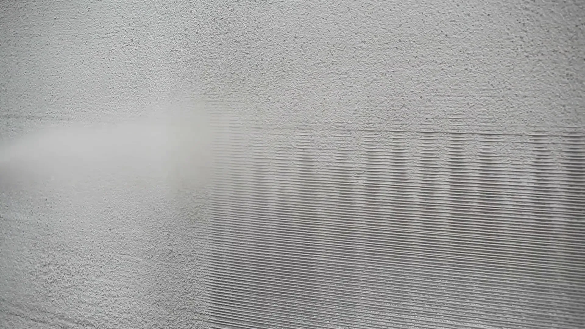 Shotcrete machine spraying concrete onto vertical surface