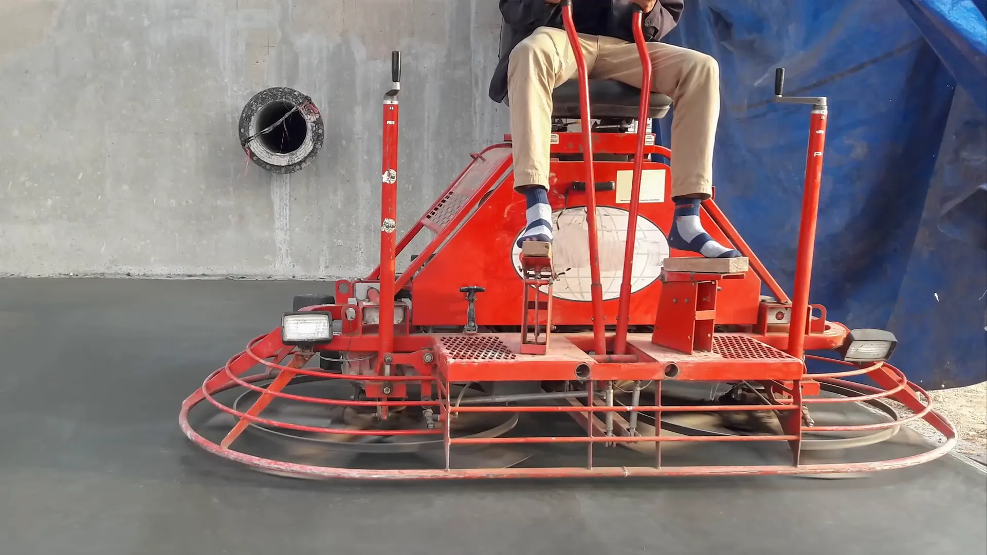 Ride-on trowel smoothing concrete slab