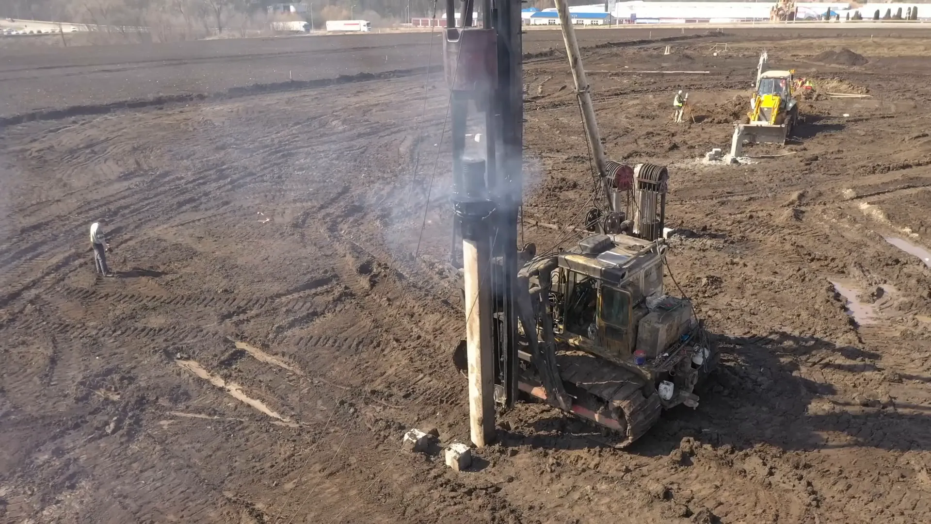 Pile driver striking piles into earth