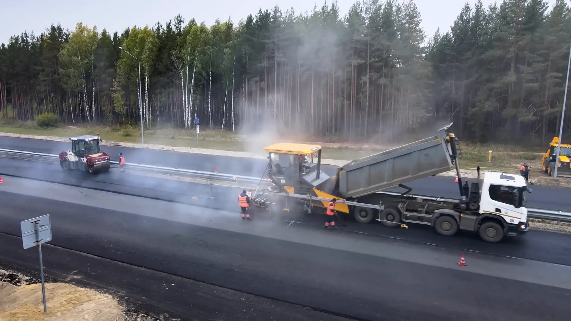 Asphalt paver laying hot asphalt on road