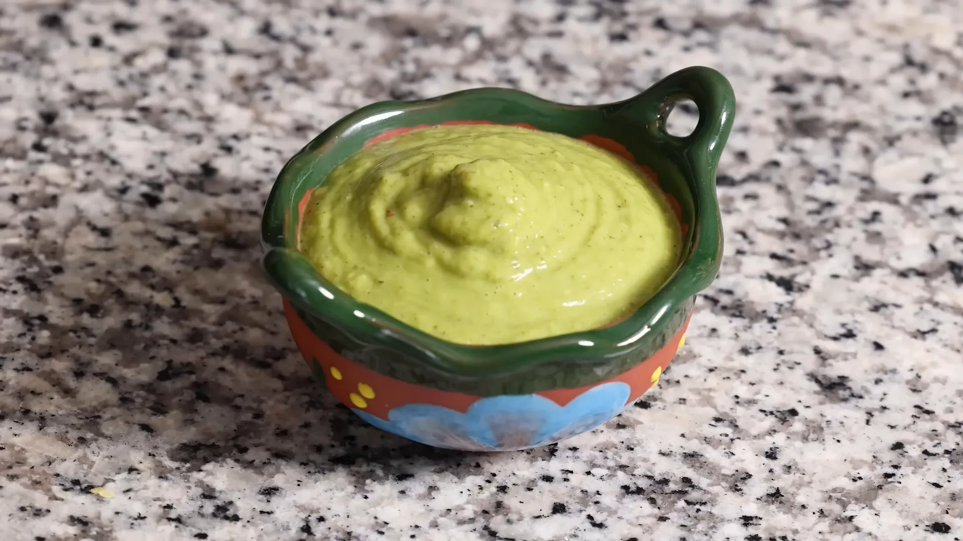 Creamy avocado salsa verde in glass bowl