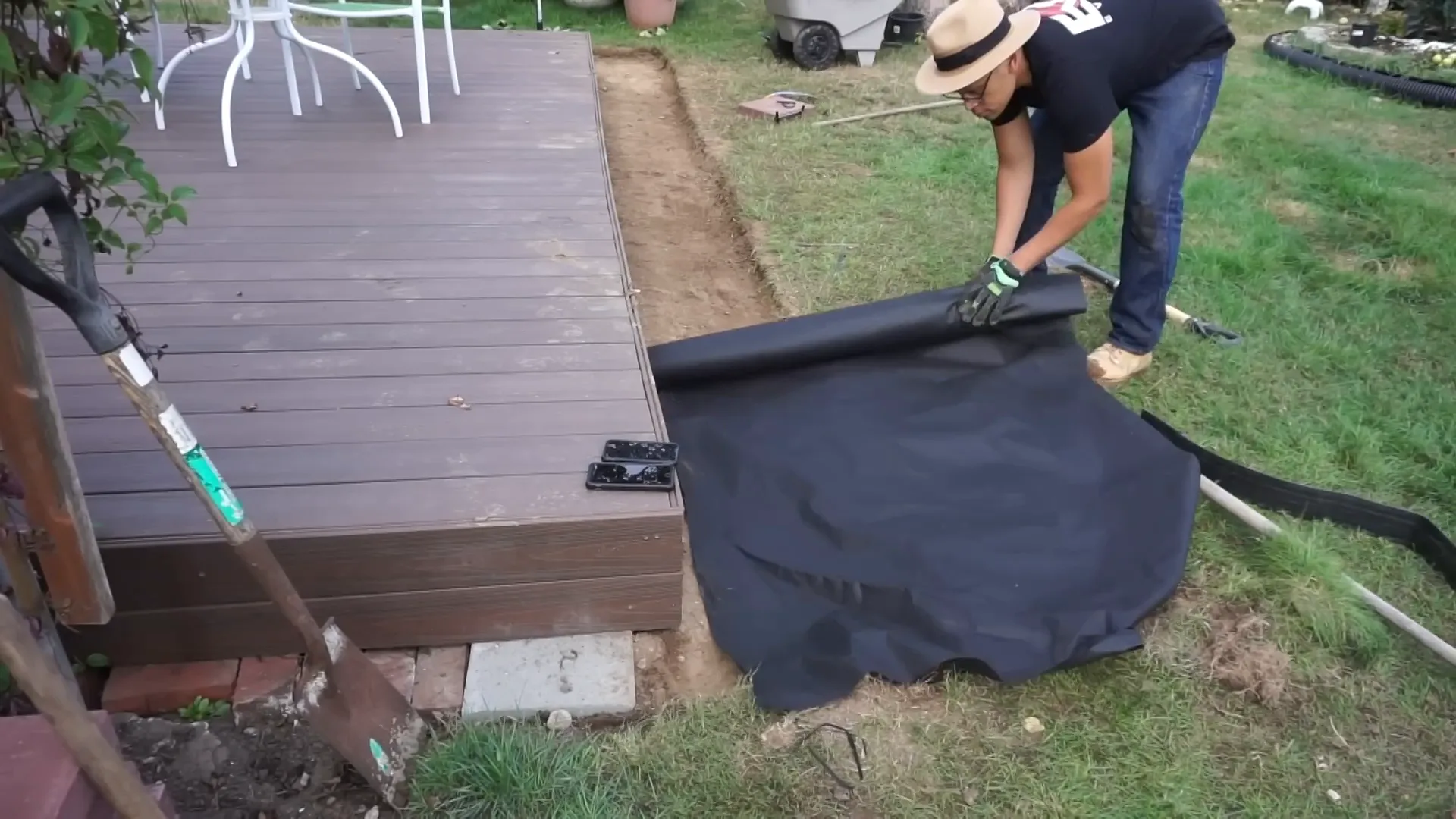 Laying down weed barrier mat
