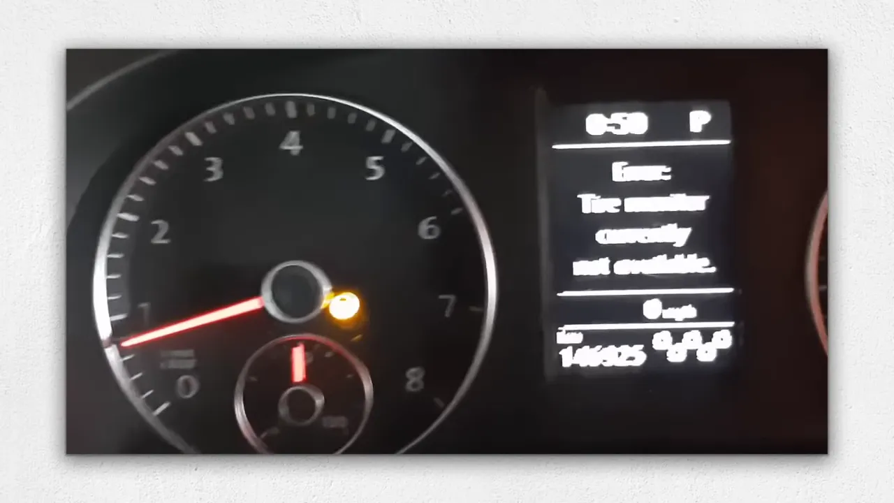 Car instrument cluster with tachometer and center digital display showing a warning light
